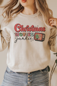 a woman wearing a christmas sweatshirt and jeans