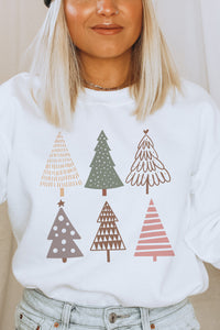 a woman wearing a white sweatshirt with christmas trees on it