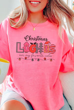 Load image into Gallery viewer, a woman wearing a pink christmas sweatshirt sitting on a couch