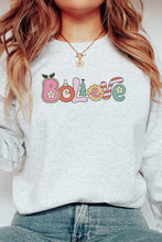 Load image into Gallery viewer, a woman wearing a sweatshirt that says believe