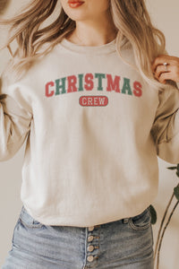 a woman wearing a christmas crew sweatshirt