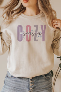 a woman wearing a cozy sweatshirt with the word cozy on it