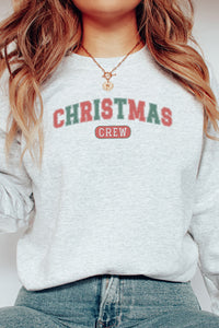 a woman wearing a christmas crew sweatshirt