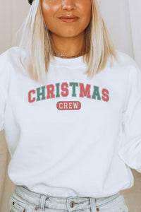a woman wearing a white christmas crew sweatshirt